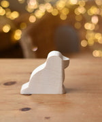 Ostheimer dog paint your own wooden figure placed on a wooden surface. 