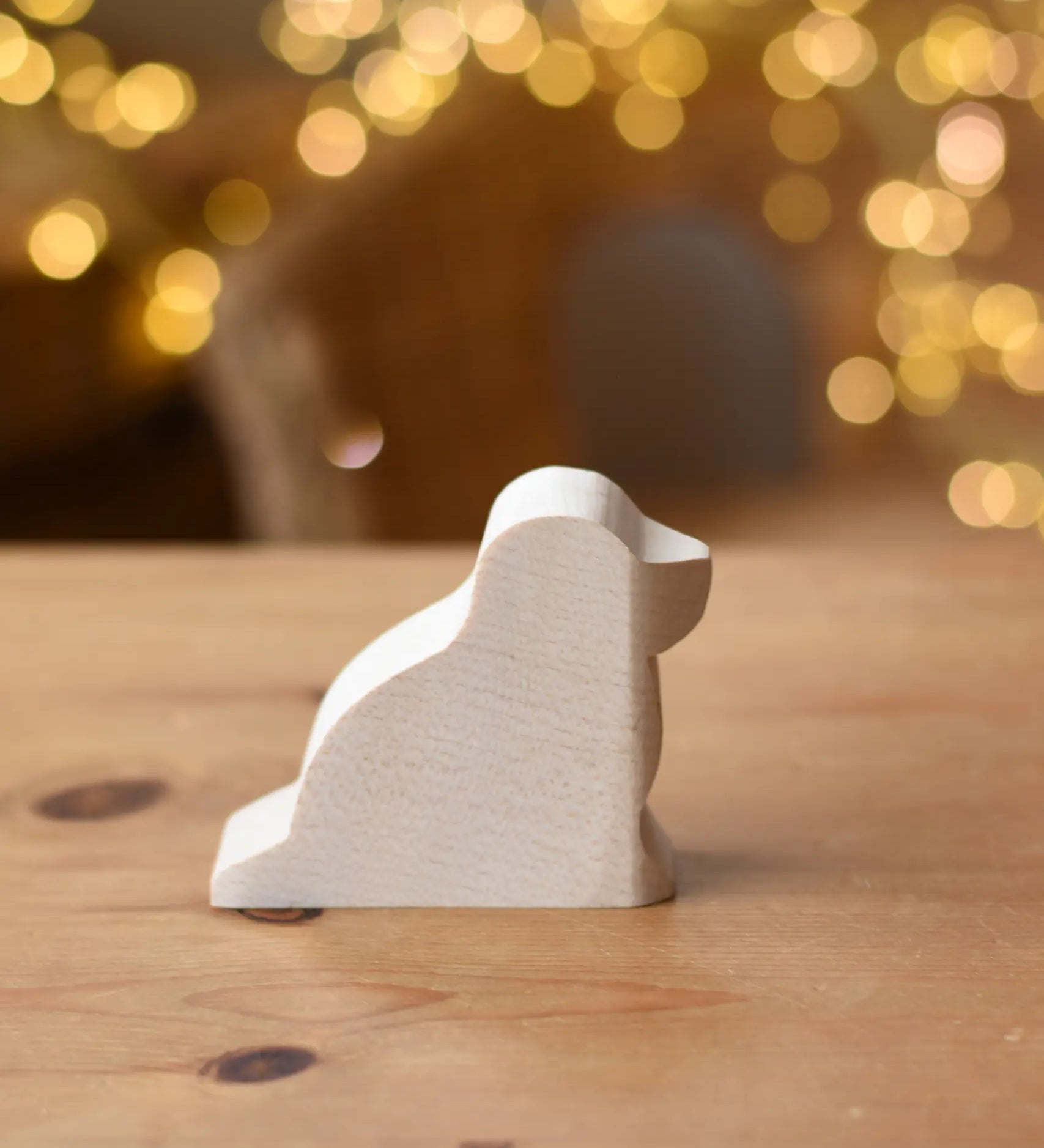 Ostheimer dog paint your own wooden figure placed on a wooden surface. 