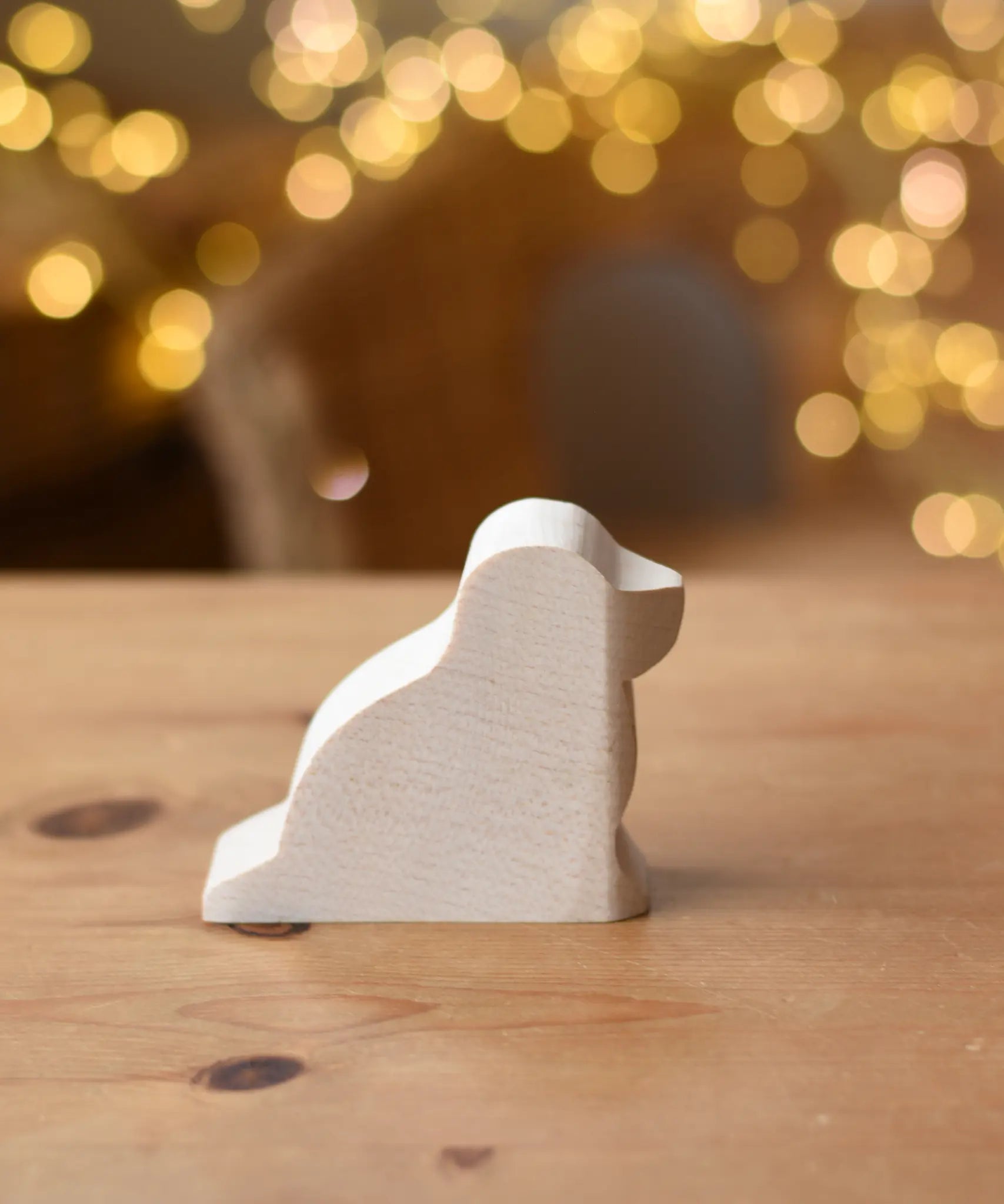 Ostheimer dog paint your own wooden figure placed on a wooden surface. 