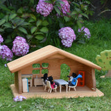 A Ostheimer wooden dolls house set up with PlanToys dolls and furniture inside. These wooden figures are part of a large range of expertly hand crafted, Waldorf inspired, wooden toys here at Babipur.