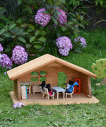 A Ostheimer wooden dolls house set up with PlanToys dolls and furniture inside. These wooden figures are part of a large range of expertly hand crafted, Waldorf inspired, wooden toys here at Babipur.