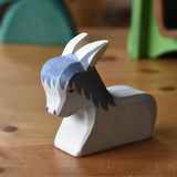Ostheimer donkey laying down wooden toy figure placed on a wooden surface.