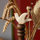 Ostheimer white dove wooden bird figure placed on a wooden stick. 
