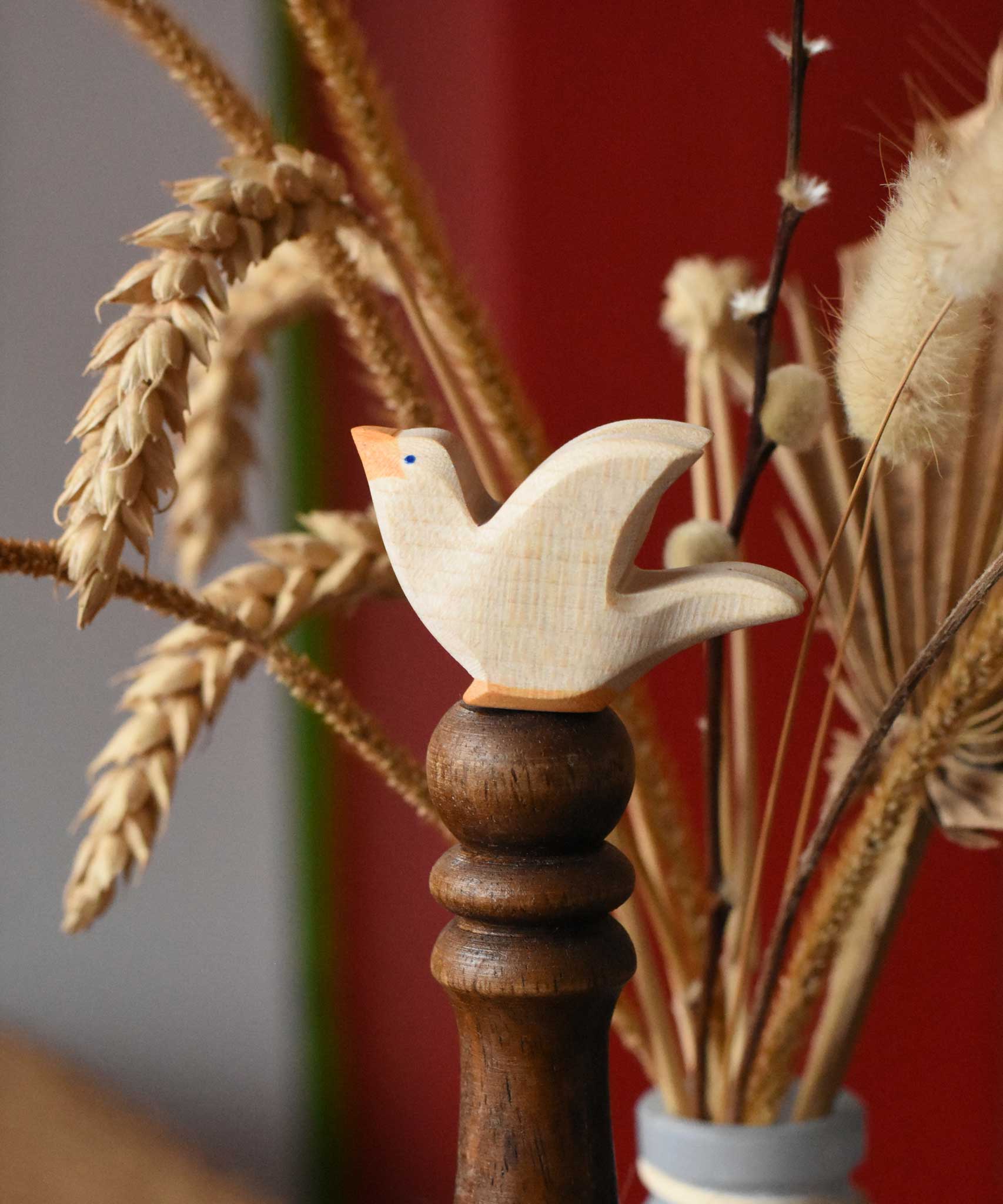 Ostheimer white dove wooden bird figure placed on a wooden stick. 