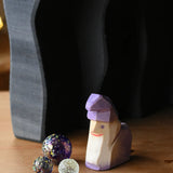 Ostheimer amethyst purple wooden dwarf figure placed underneath the dragon's cave arches next to three Billes glass marbles. 