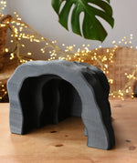 Ostheimer black wooden dragon's cave scenery piece toy placed on a wooden surface. 