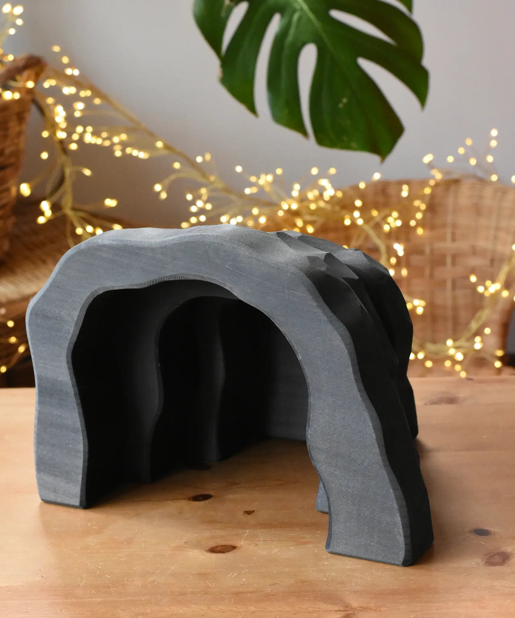 Ostheimer black wooden dragon's cave scenery piece toy placed on a wooden surface. 