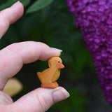 An Ostheimer ducking wooden toy figure shown held up in an adult's hand to show scale.