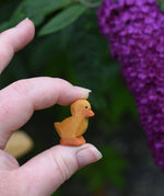 An Ostheimer ducking wooden toy figure shown held up in an adult's hand to show scale.