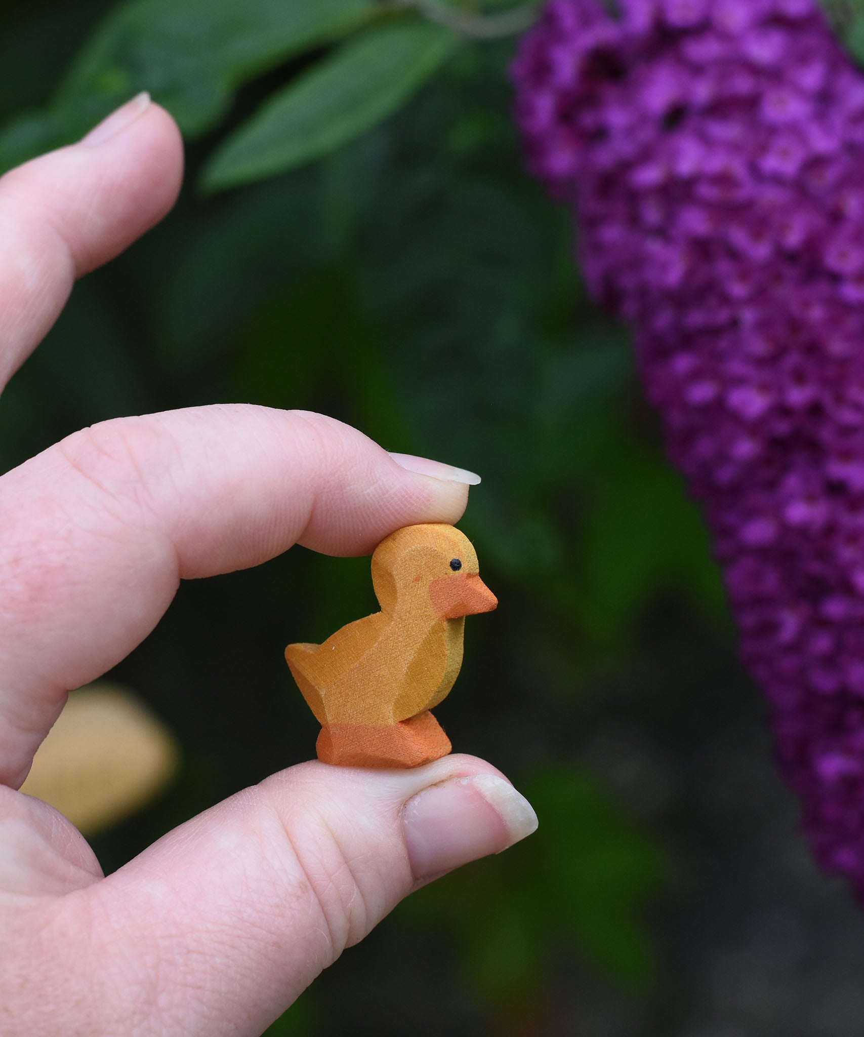 An Ostheimer ducking wooden toy figure shown held up in an adult's hand to show scale.