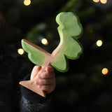 A close up of a child's hand holding an Ostheimer eucalyptus tree wooden toy figure. These wooden figures are part of a wide range of expertly hand crafted wooden toys here at Babipur. 