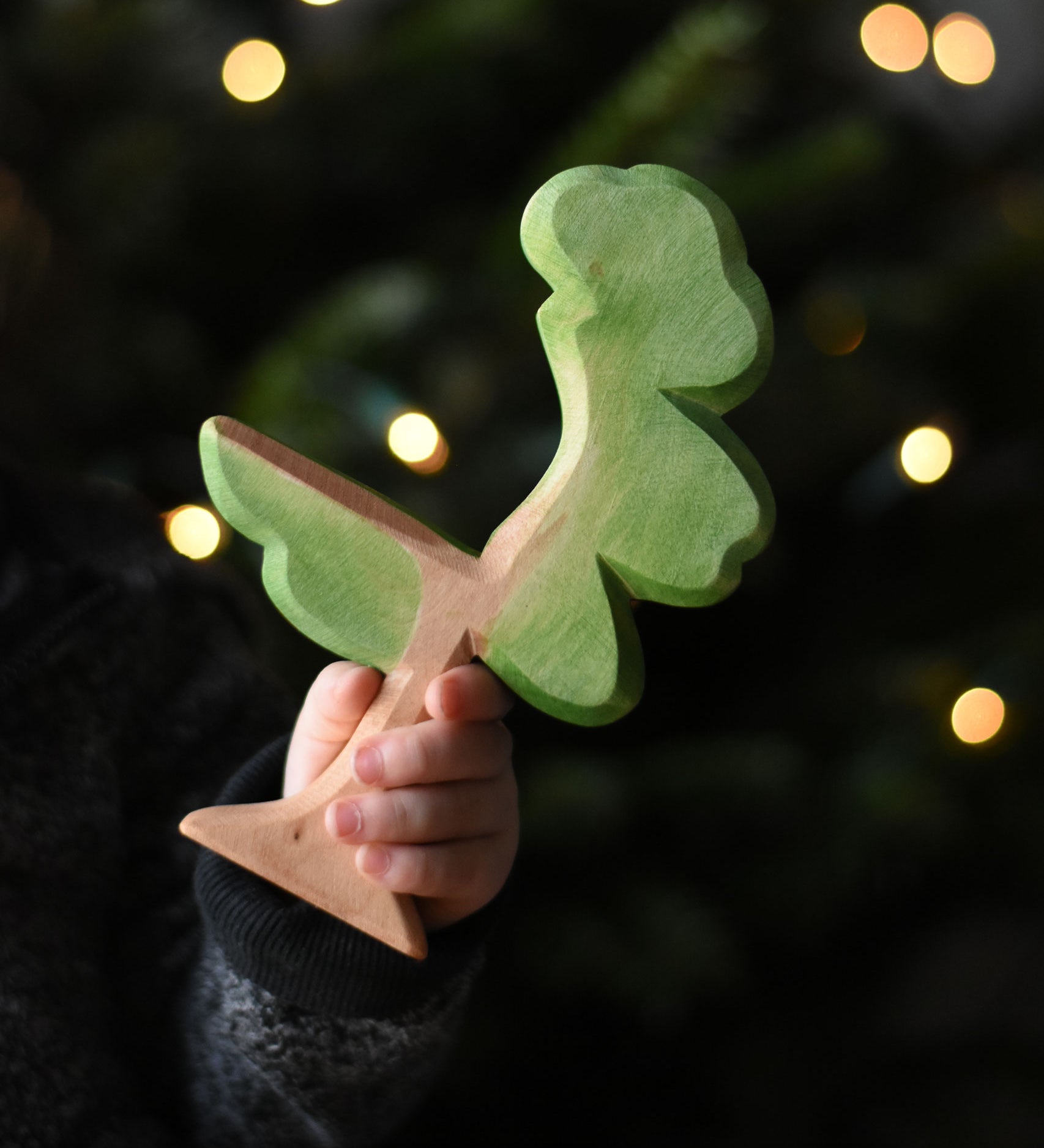 A close up of a child's hand holding an Ostheimer eucalyptus tree wooden toy figure. These wooden figures are part of a wide range of expertly hand crafted wooden toys here at Babipur. 