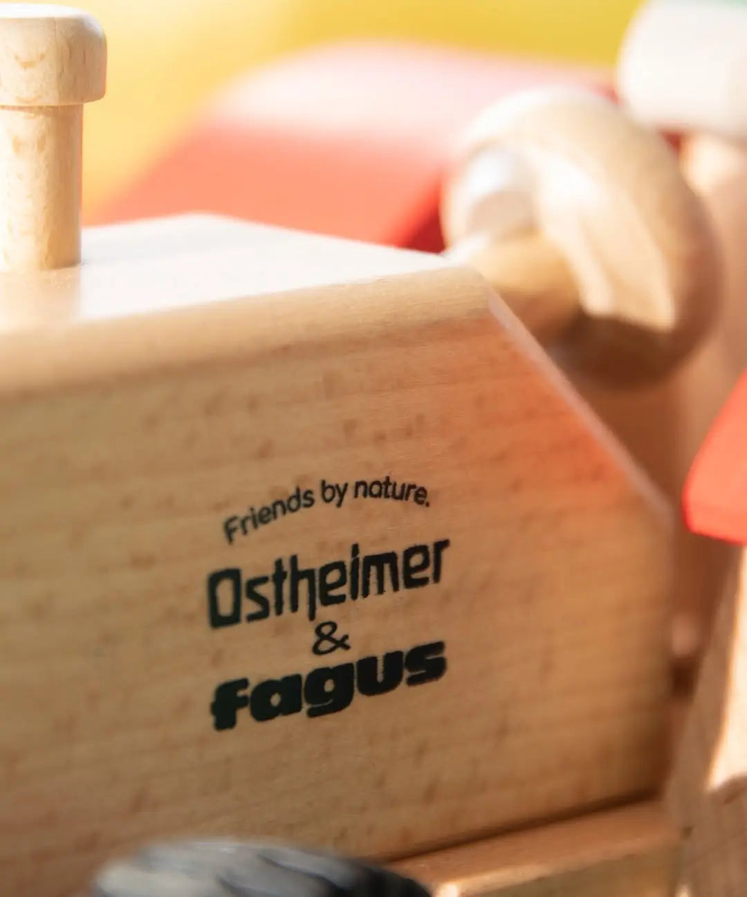 Close-up of the Ostheimer and Fagus Friends by Nature logo printed on the sustainable beech wooden tractor body.