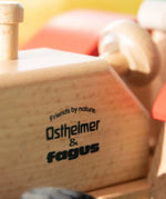 Close-up of the Ostheimer and Fagus Friends by Nature logo printed on the sustainable beech wooden tractor body.