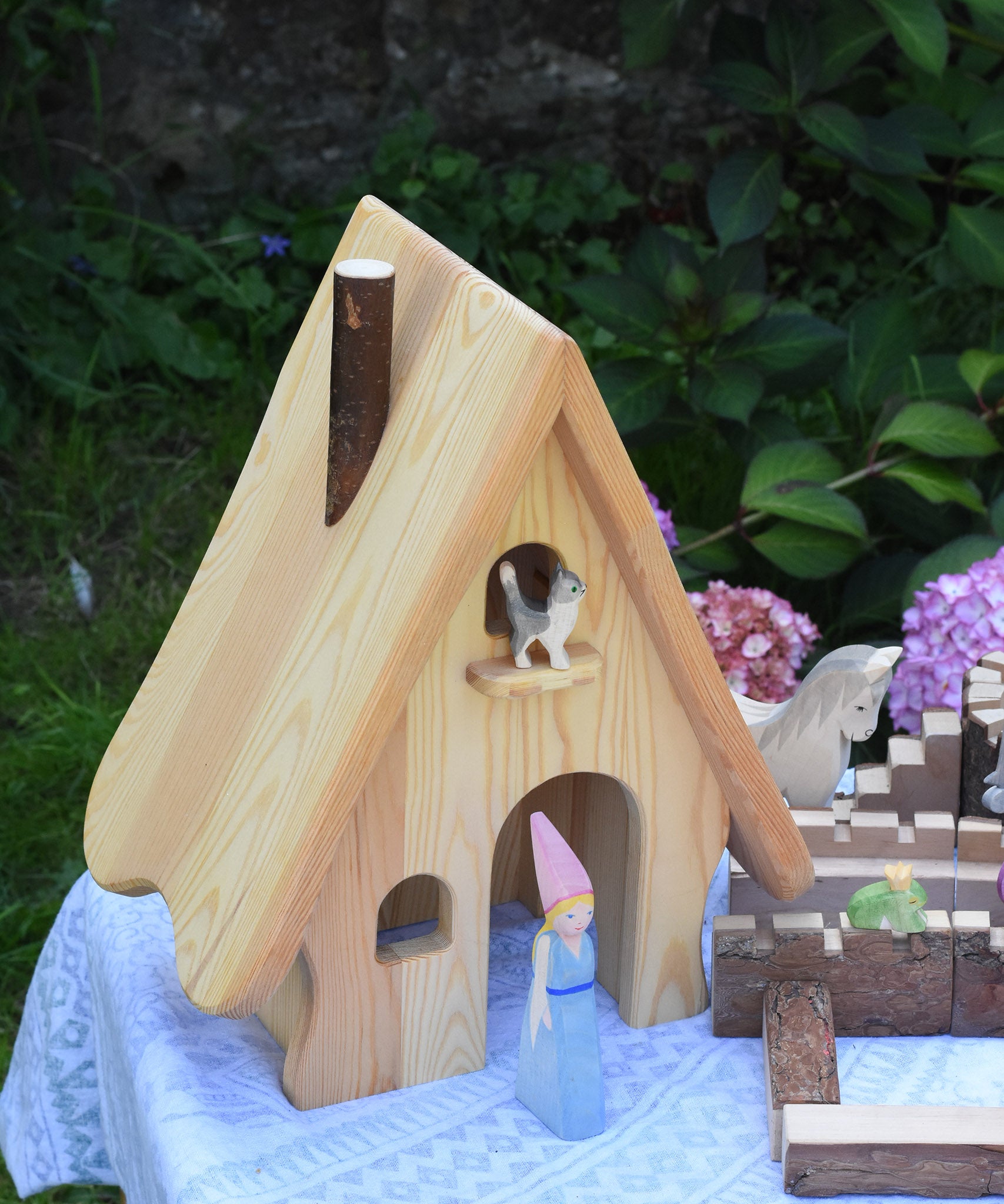 An Ostheimer fairy tale dolls house with a medieval princess stood in the door way and a cat on the bird perch.
These wooden figures are part of a large range of expertly hand crafted, Waldorf inspired, wooden toys here at Babipur. 