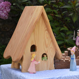 An Ostheimer Fairy Tale dolls house shown from behind with the  princess and frog prince wooden toy figures. These wooden figures are part of a large range of expertly hand crafted, Waldorf inspired, wooden toys here at Babipur. 