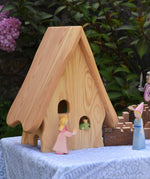 An Ostheimer Fairy Tale dolls house shown from behind with the  princess and frog prince wooden toy figures. These wooden figures are part of a large range of expertly hand crafted, Waldorf inspired, wooden toys here at Babipur. 