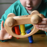 Ostheimer family van push along wooden toy with three people peg dolls. Child is tipping it upside down.