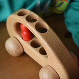 Close up of the top of the Ostheimer family van push along wooden toy with one of the peg dolls inside.
