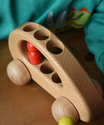 Close up of the top of the Ostheimer family van push along wooden toy with one of the peg dolls inside.