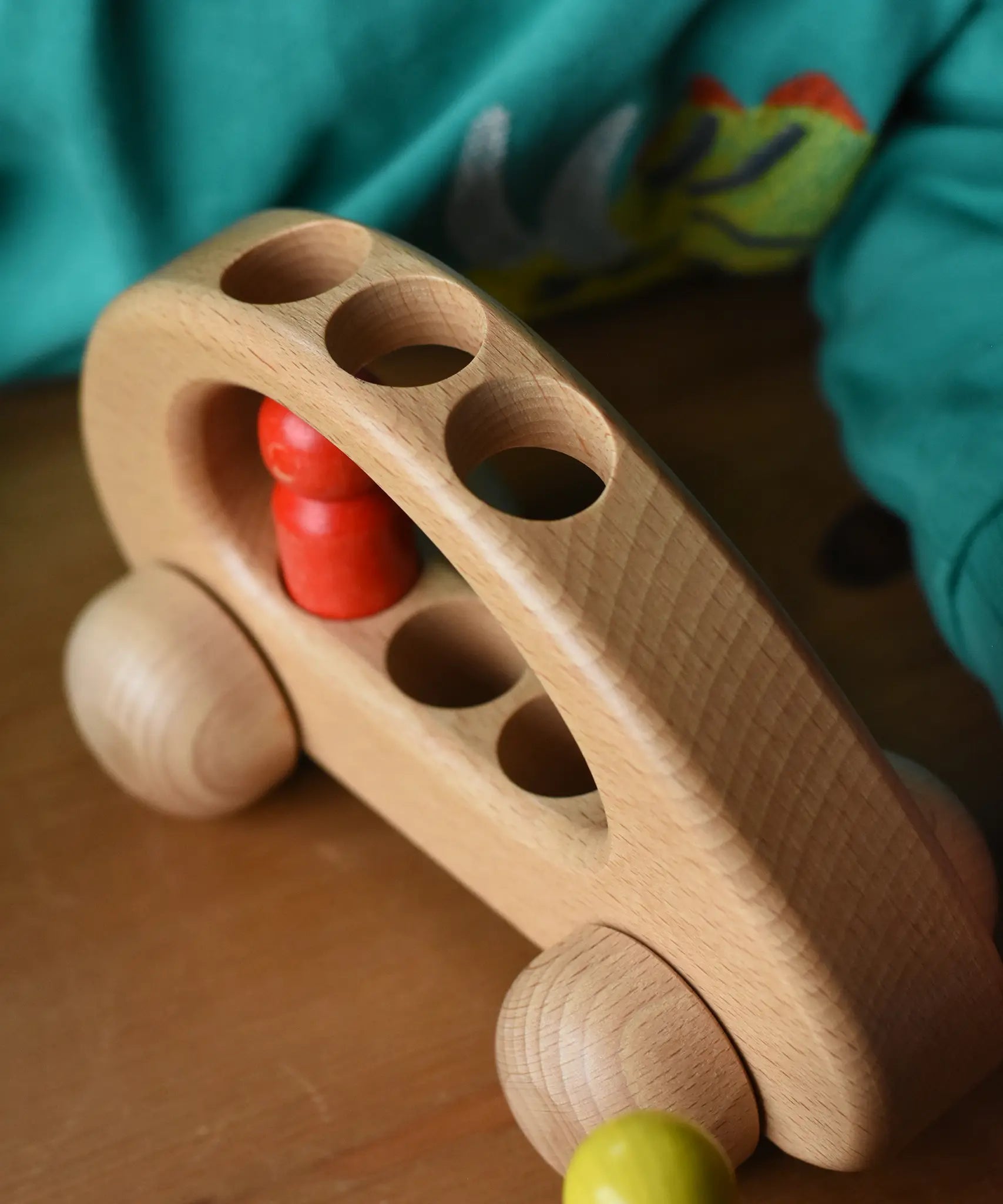 Close up of the top of the Ostheimer family van push along wooden toy with one of the peg dolls inside.