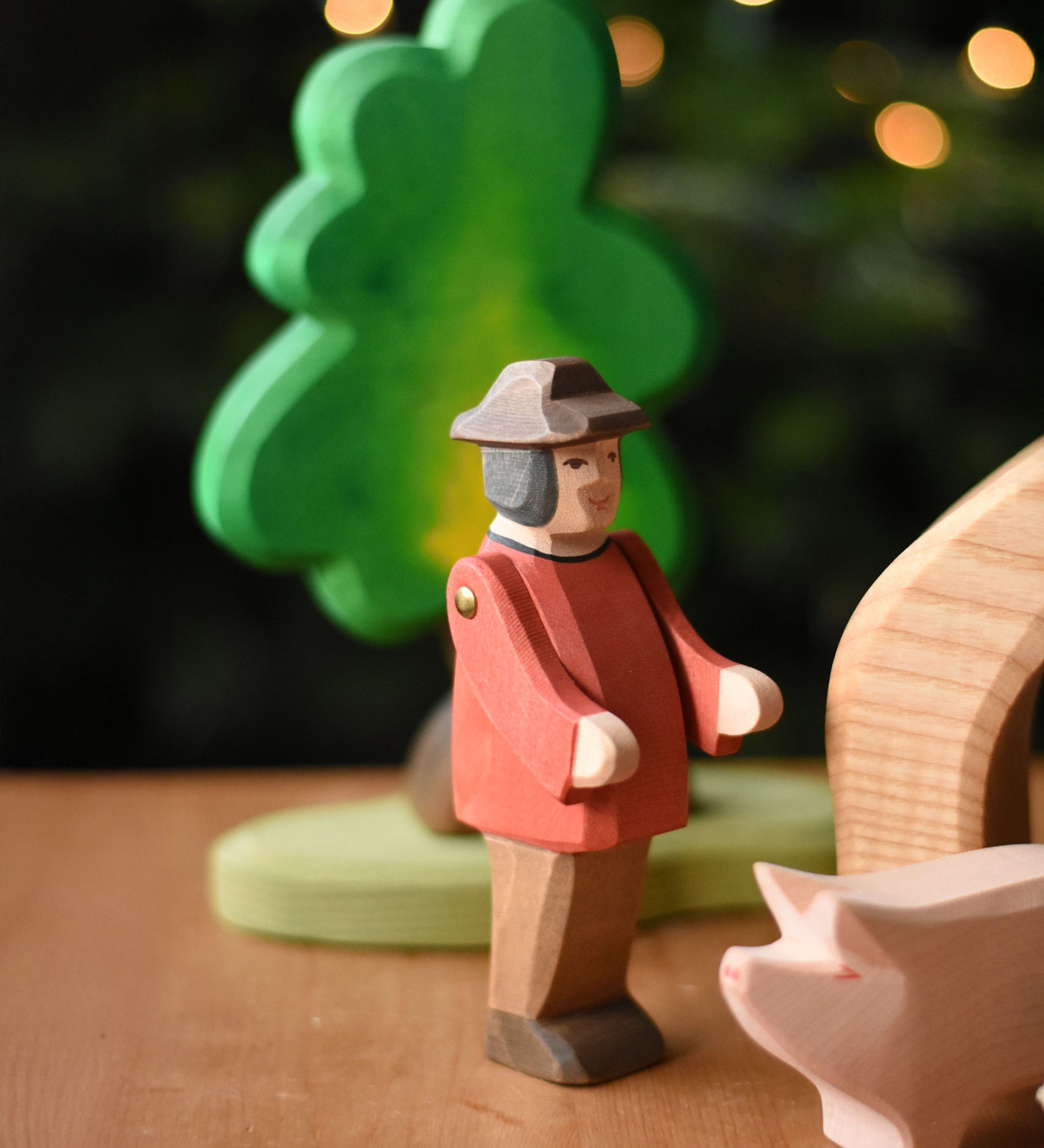 An Ostheimer farmer man figure placed in a small world play scene set up on a wooden surface. These wooden figures are part of a wide range of expertly hand crafted wooden toys here at Babipur. 