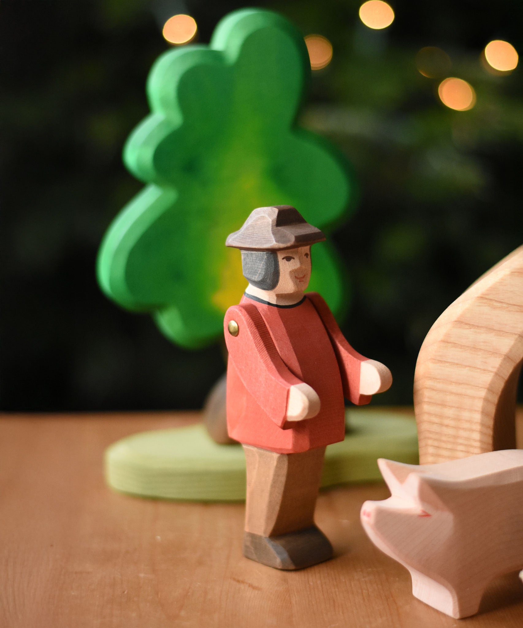 An Ostheimer farmer man figure placed in a small world play scene set up on a wooden surface. These wooden figures are part of a wide range of expertly hand crafted wooden toys here at Babipur. 
