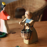 Ostheimer farmer woman wooden toy figure with a small Kraul basket filled with flay Billes marbles placed inside hung on her arms.