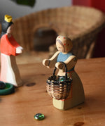 Ostheimer farmer woman wooden toy figure with a small Kraul basket filled with flay Billes marbles placed inside hung on her arms.