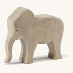 A wooden Ostheimer female elephant figure on a cream background.