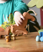 Ostheimer female lioness wooden toy figure in a child's hand in a small world play scene. 