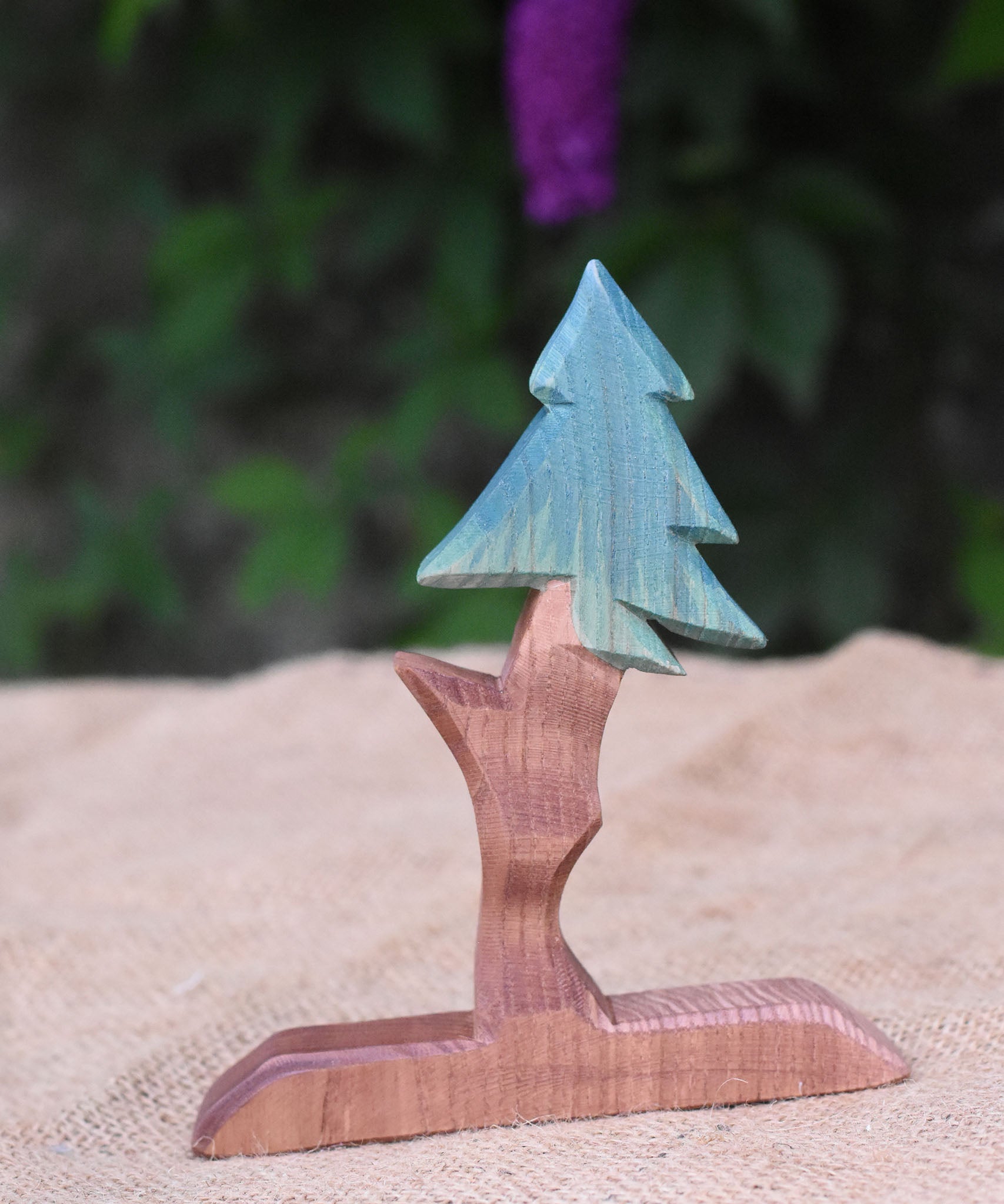 An Ostheimer wooden fir tree placed n a jute covered surface. 