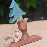 An Ostheimer robin placed on teh base of on an Ostheimer fir tree.