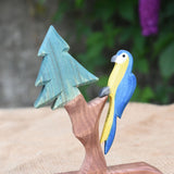An Ostheimer blue parrot toy perching on the fir tree for dwarves.