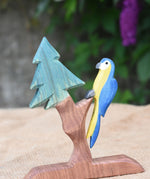 An Ostheimer blue parrot toy perching on the fir tree for dwarves.