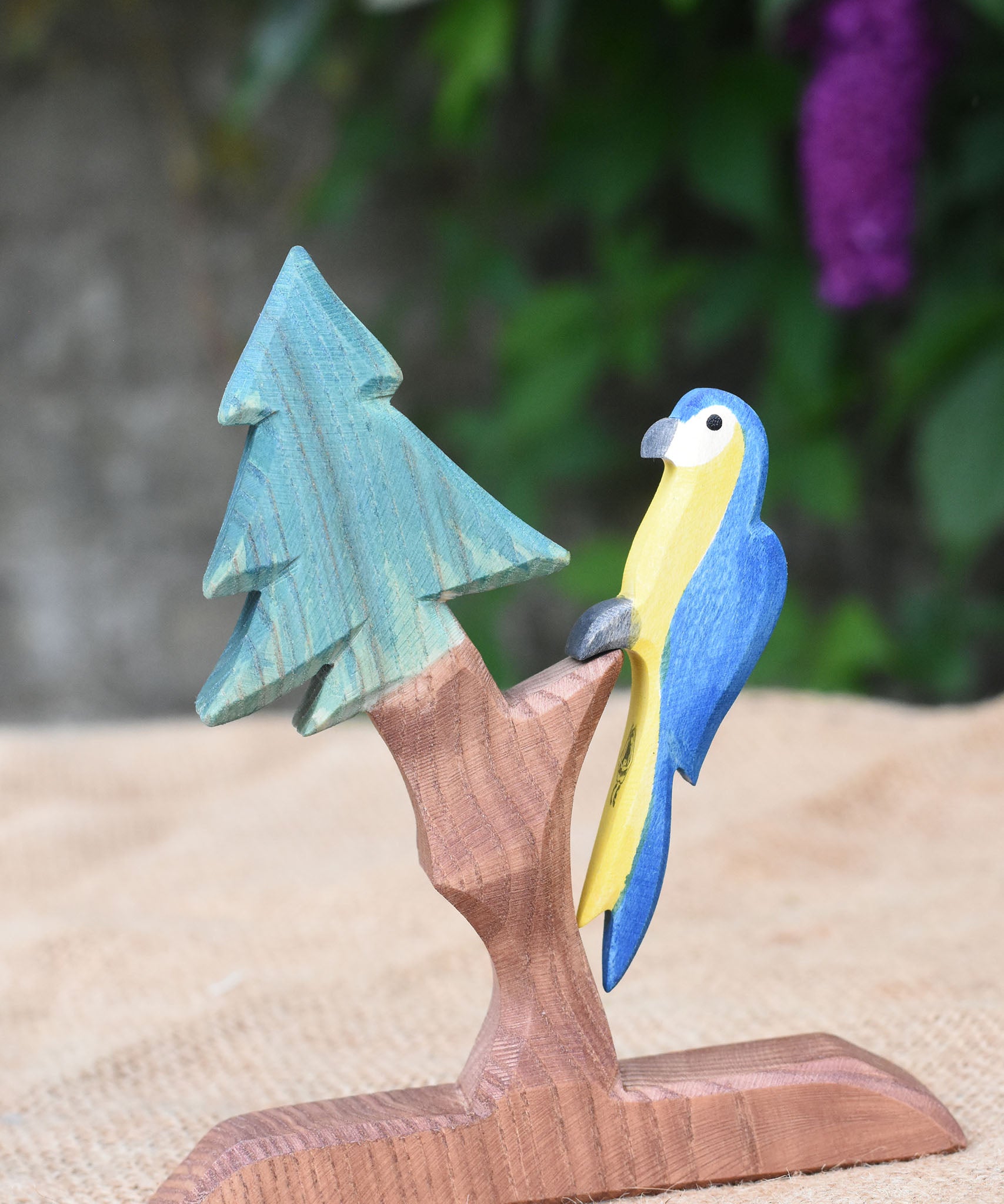 An Ostheimer blue parrot toy perching on the fir tree for dwarves.