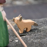 Ostheimer German shepherd wooden toy figure placed on a stone wall outdoors. 