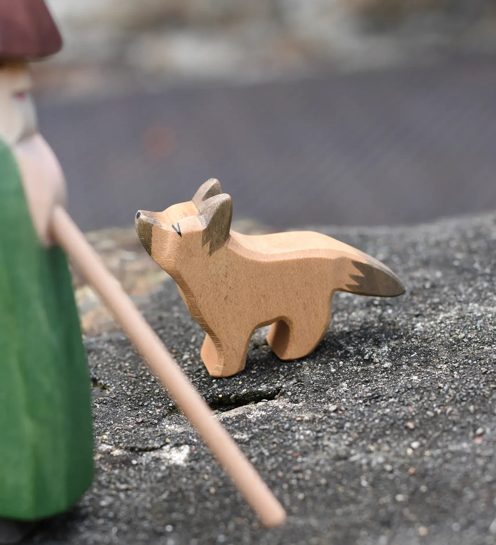 Ostheimer German shepherd wooden toy figure placed on a stone wall outdoors. 