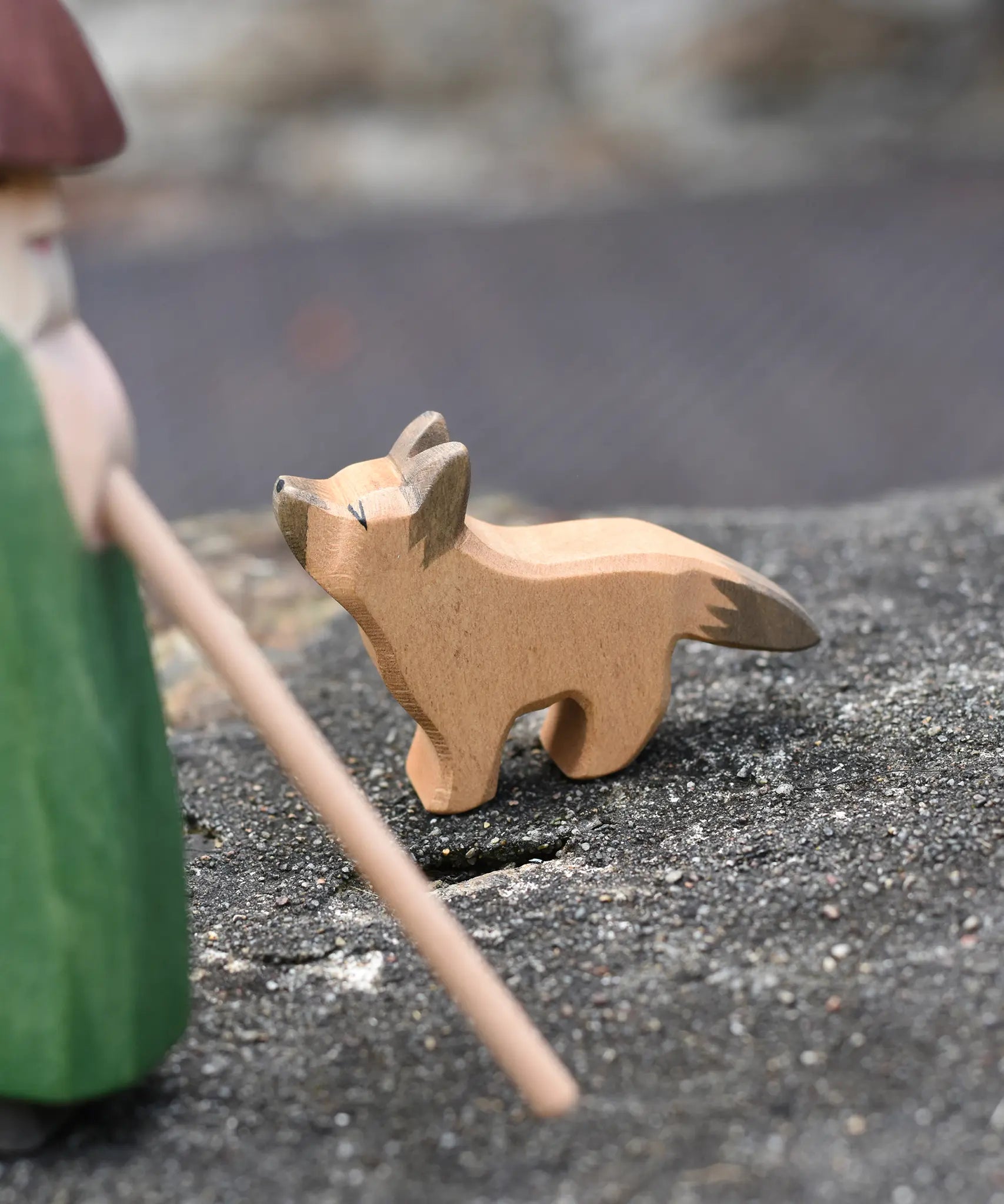 Ostheimer German shepherd wooden toy figure placed on a stone wall outdoors. 