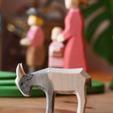 Ostheimer small grey white goat kid placed in front of people figures in a play scene.