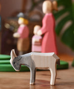 Ostheimer small grey white goat kid placed in front of people figures in a play scene.