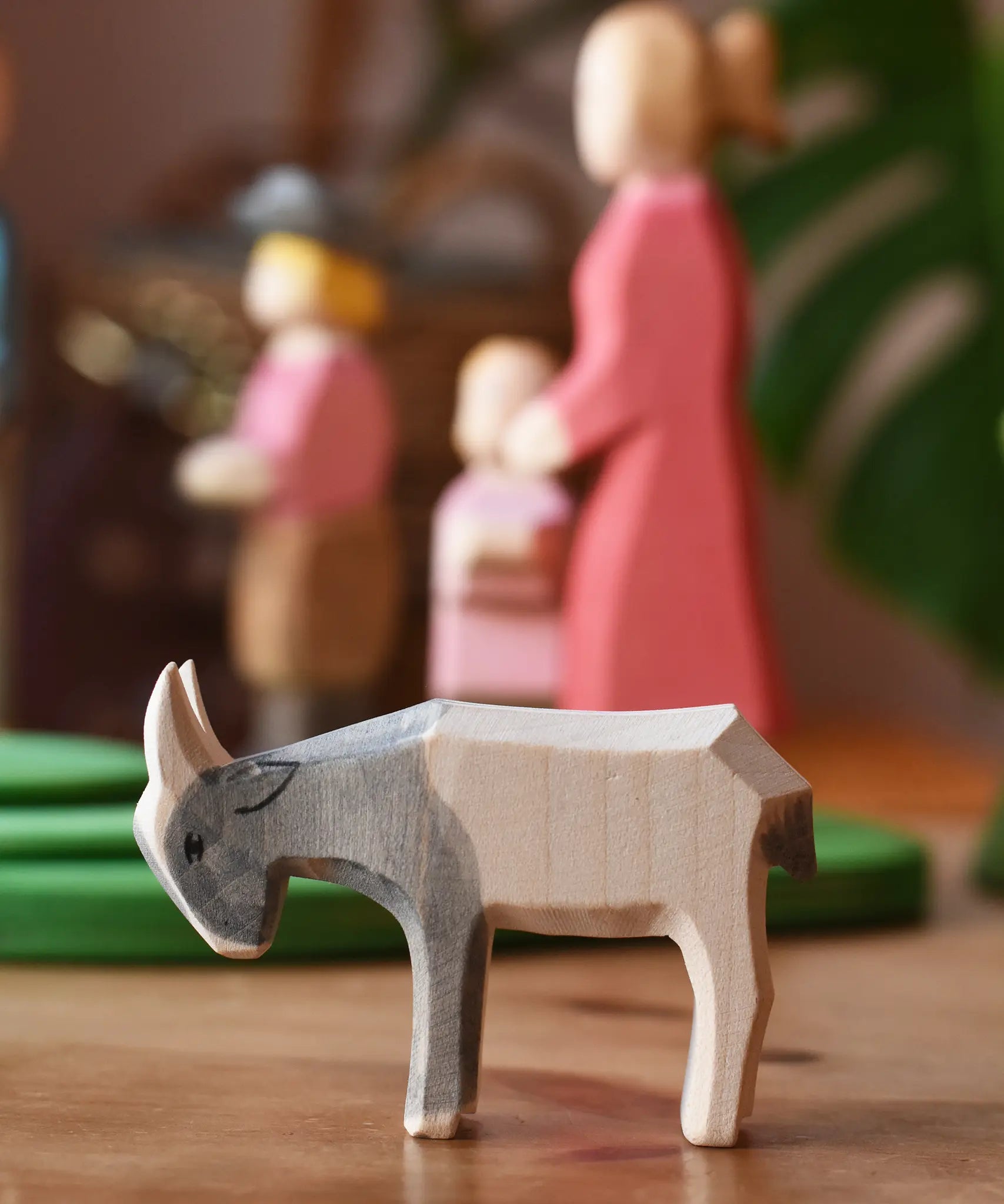 Ostheimer small grey white goat kid placed in front of people figures in a play scene.