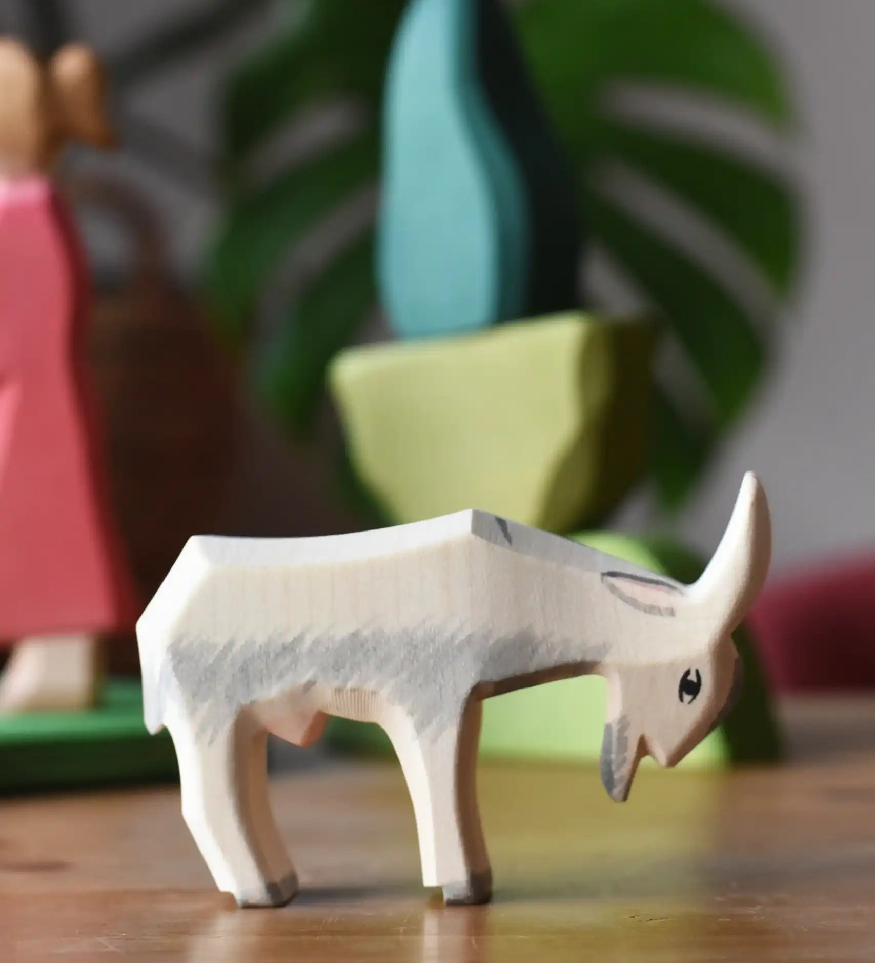 Ostheimer white goat wooden toy figure with green bush scenery pieces in the background.