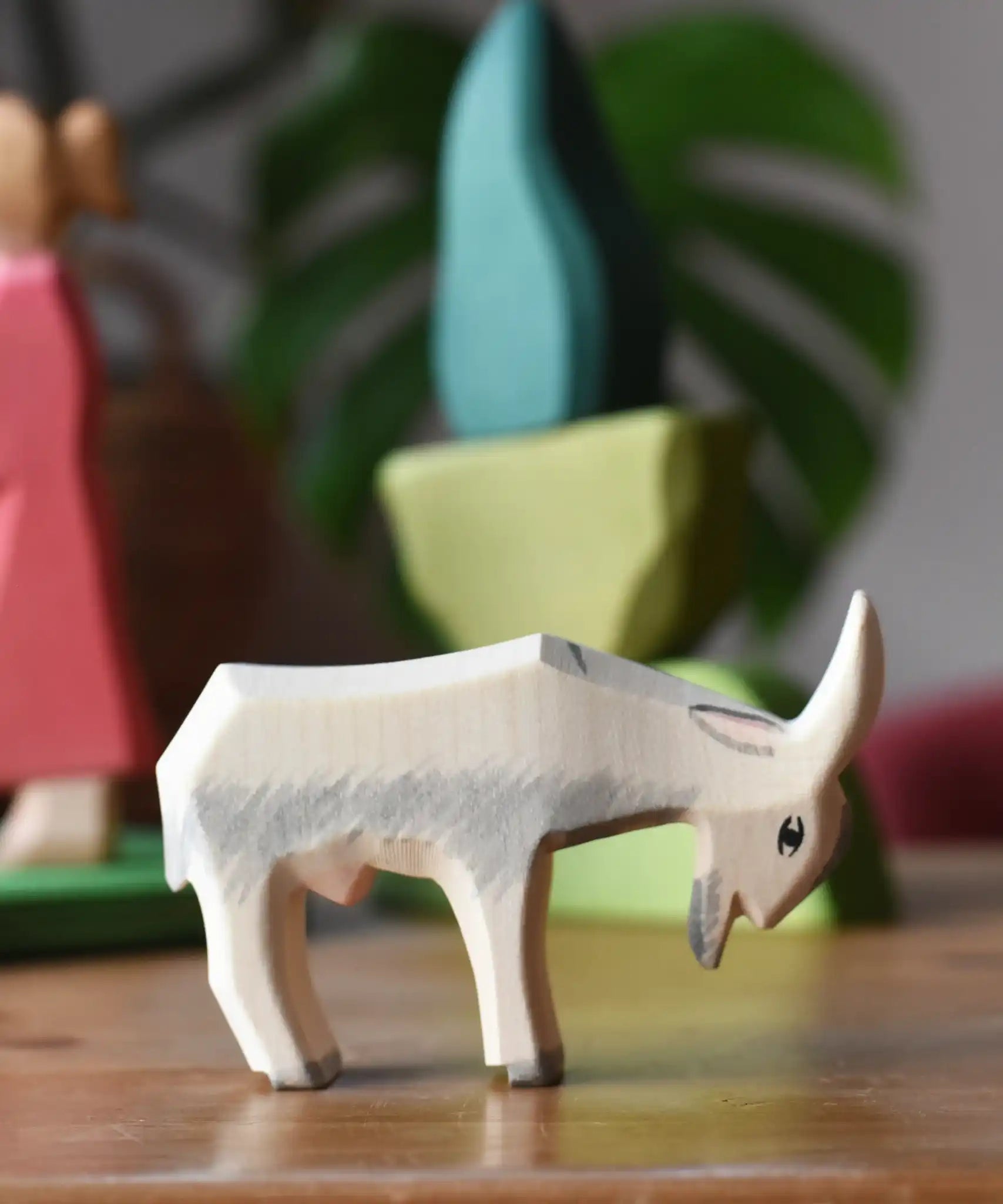 Ostheimer white goat wooden toy figure with green bush scenery pieces in the background.