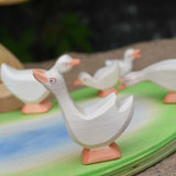 Ostheimer goose with it's head high placed in a small world play scene with a gaggle of geese and goslings. 