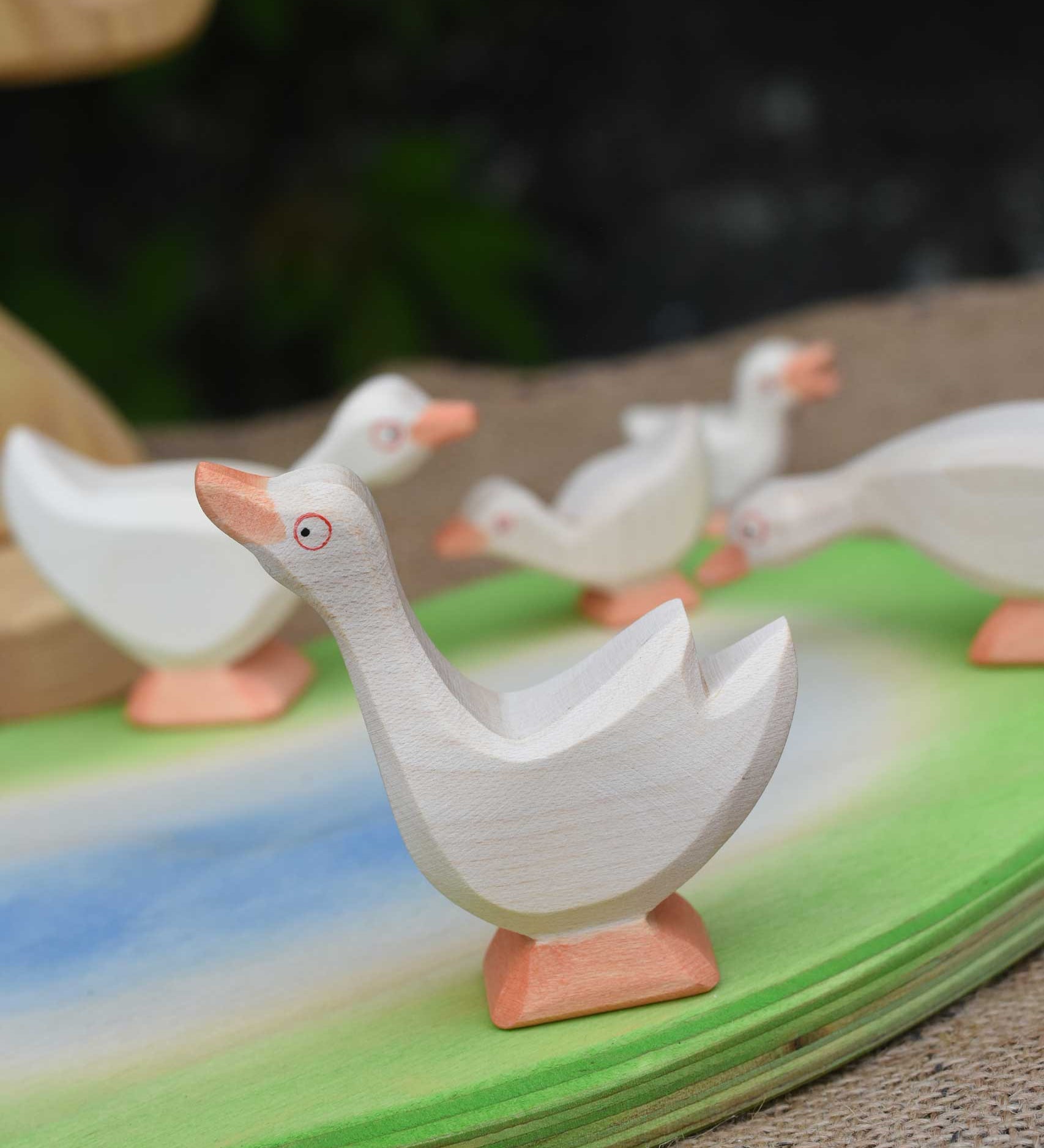 Ostheimer goose with it's head high placed in a small world play scene with a gaggle of geese and goslings. 