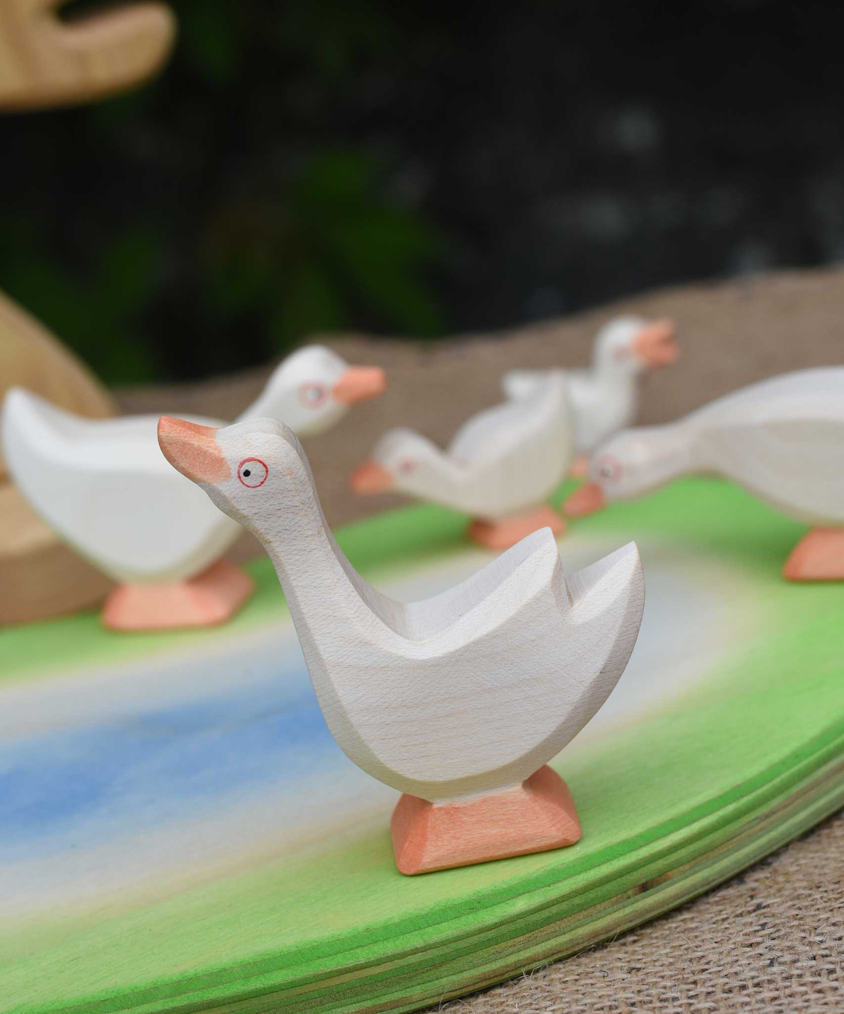 Ostheimer goose with it's head high placed in a small world play scene with a gaggle of geese and goslings. 