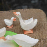 Ostheimer goose with it's head high placed in a small world play scene with a gaggle of geese and goslings. 