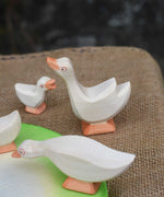 Ostheimer goose with it's head high placed in a small world play scene with a gaggle of geese and goslings. 
