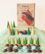 Grapat x Ostheimer Hrókur Mandala Pieces Set Wooden Toy placed on green Ostheimer cotton scarf. The box featuring an illustration of the brown horse is placed next to them in the Babipur playroom.